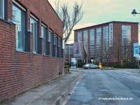 Neusser Hütte, Koppers: Die Wiesenstraße am Areal des früheren Koppers Werk 4, links bereits abgerissene Gebäude des Gießereizuliefereres Hüttenes-Albertus